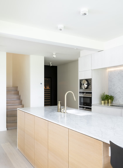 Nieuwe witte keuken met houten kasten in woning Herent
