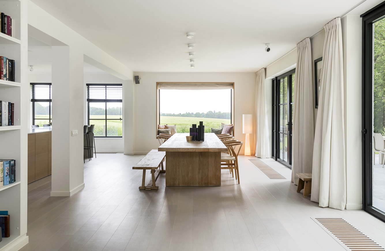 Nieuwe eetplaats met uitzicht op de tuin en open keuken in woning Herent